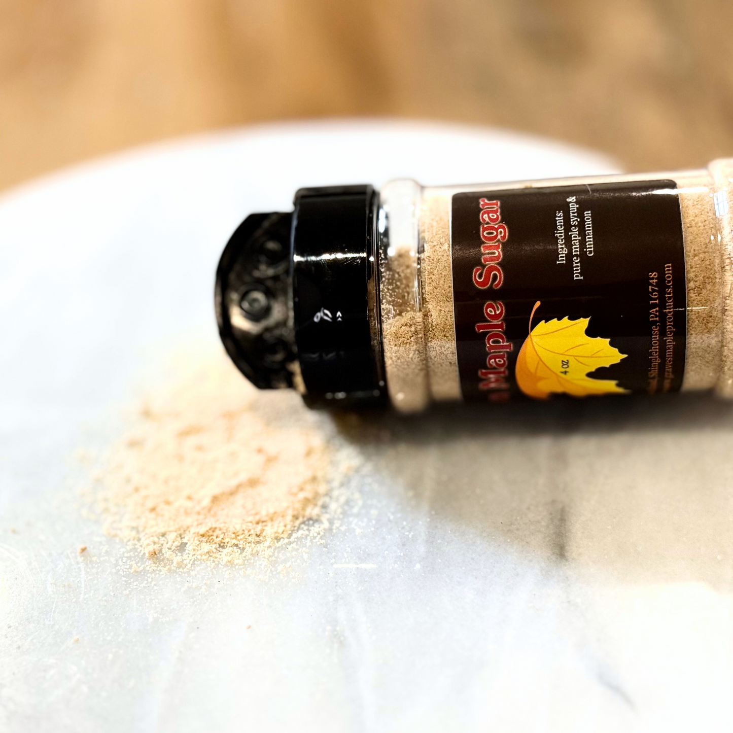 Cinnamon maple sugar spilled from 4 oz shaker – Graves Maple Products, PA on marble surface