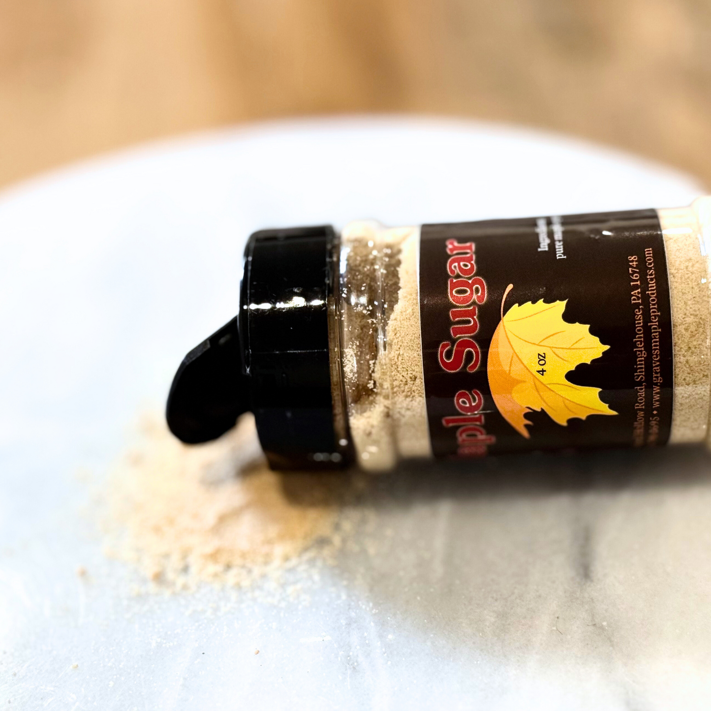 Maple sugar spilled from 4 oz shaker – Graves Maple Products on marble surface